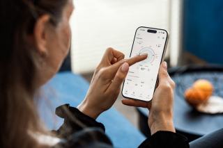 Thermostat mural connecté affichant la température de consigne dans un séjour
